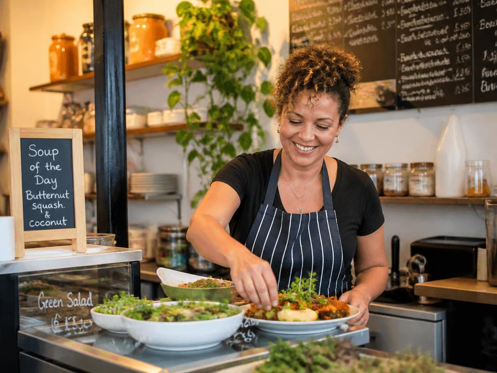 An independent restaurant owner preparing fresh food behind the counter.